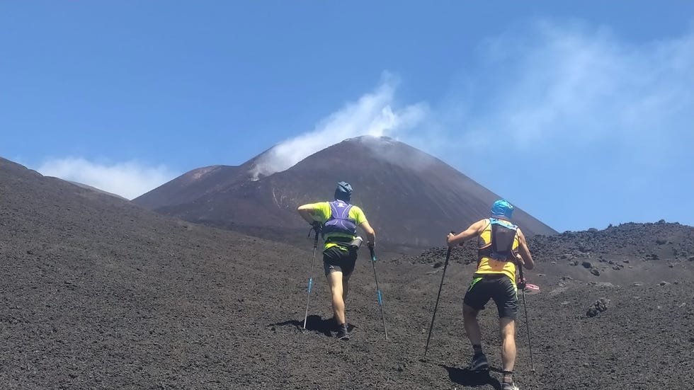 hikers climbing a volcanic landscape