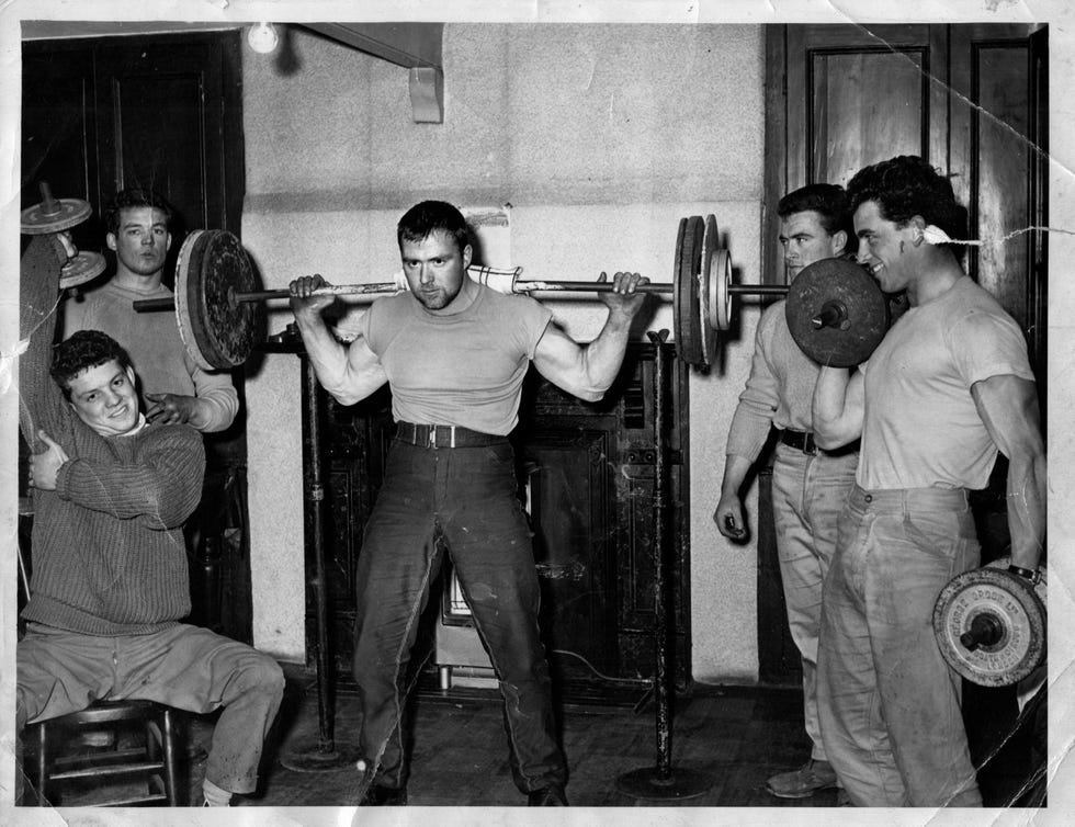 group of men participating in a weightlifting session indoors