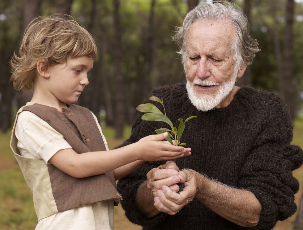abuelo y nieto sujetando un esqueje de una planta