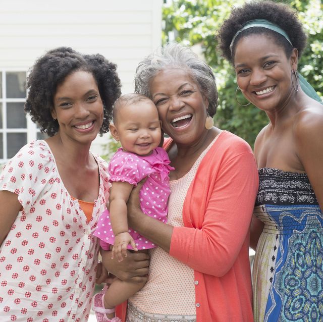 grandma, two grown daughters, and baby girl smiling in backyard