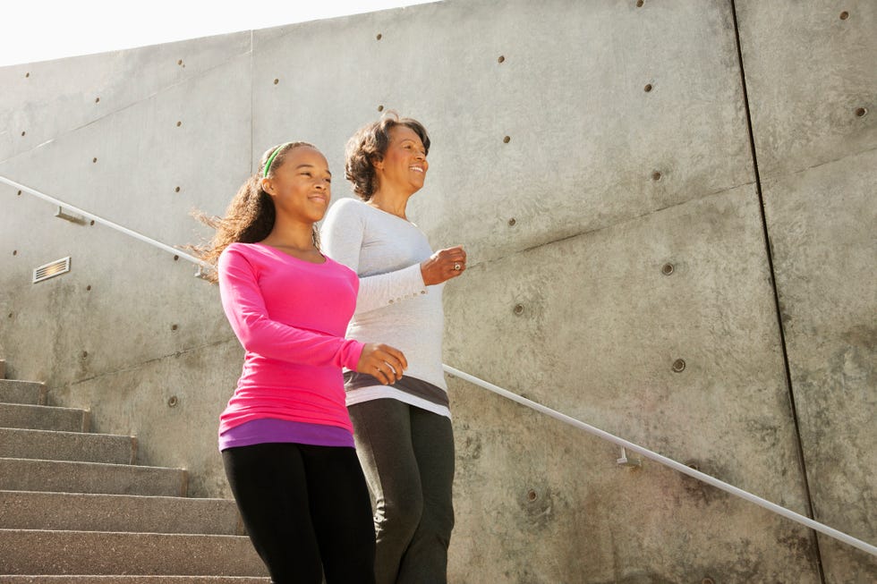 grandmother and granddaughter running down urban steps