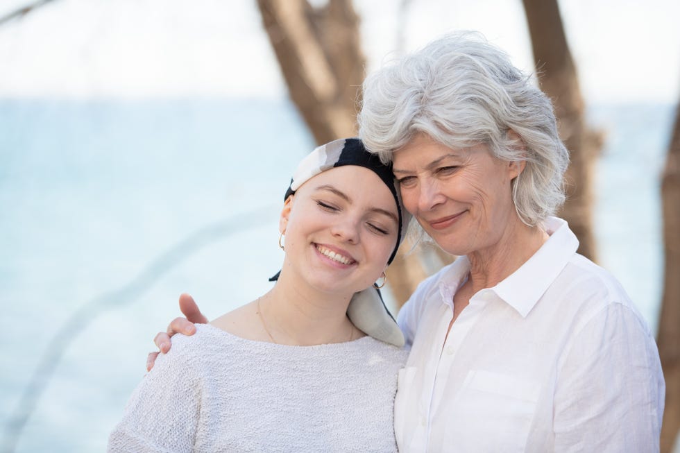 grandmother hugging her granddaughter with cancer stock photo