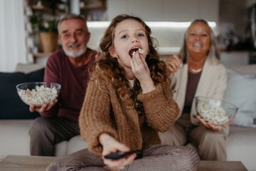 grandparents watching tv with their granddaughter