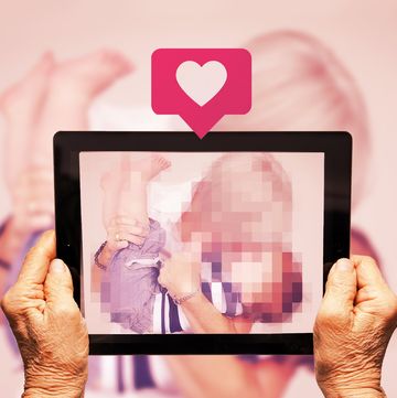 old hands holding up a tablet with a like button above while taking a photo of grandma and grandson