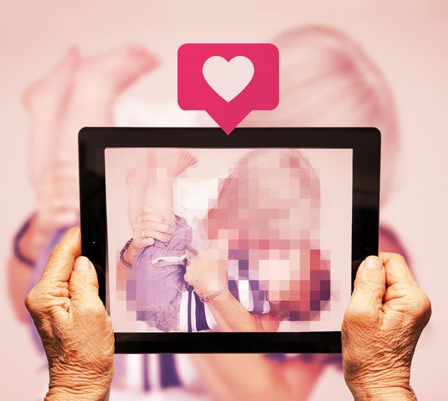 old hands holding up a tablet with a like button above while taking a photo of grandma and grandson