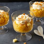 three glasses of pineapple granita topped with whipped cream and toasted coconut flakes