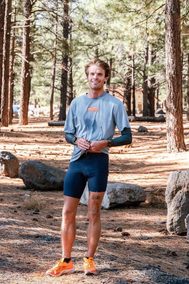man standing in forest in running clothes