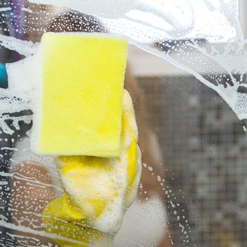 great concept of domestic cleaning, young blond woman cleaning glass from the bathroom