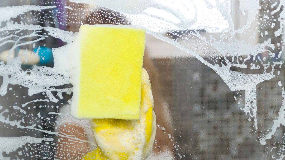 great concept of domestic cleaning, young blond woman cleaning glass from the bathroom