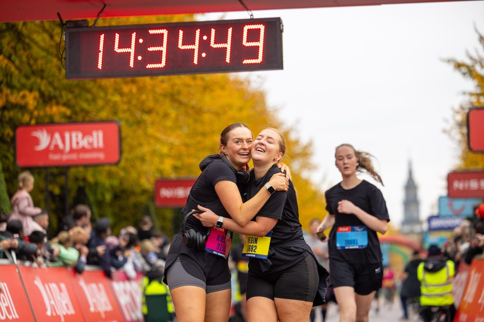 runners embracing each other at the finish line of a race