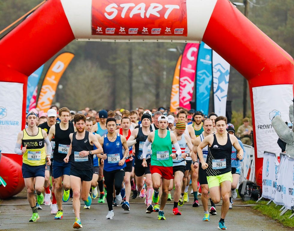 a group of people running under a starting line