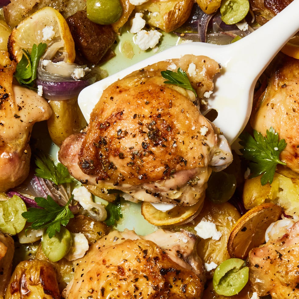 greek lemon butter chicken with smashed potatoes and olives on a sheet pan