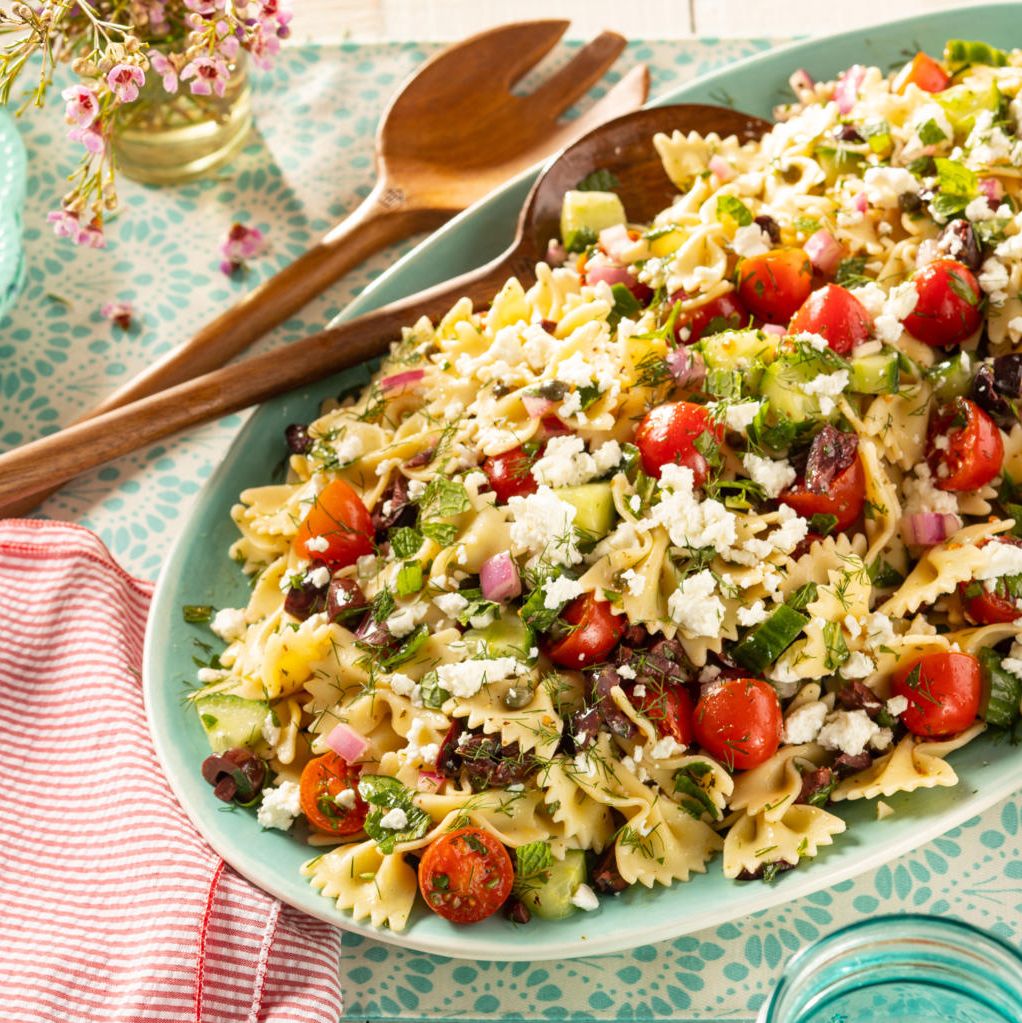 greek pasta salad with wooded serving spoons