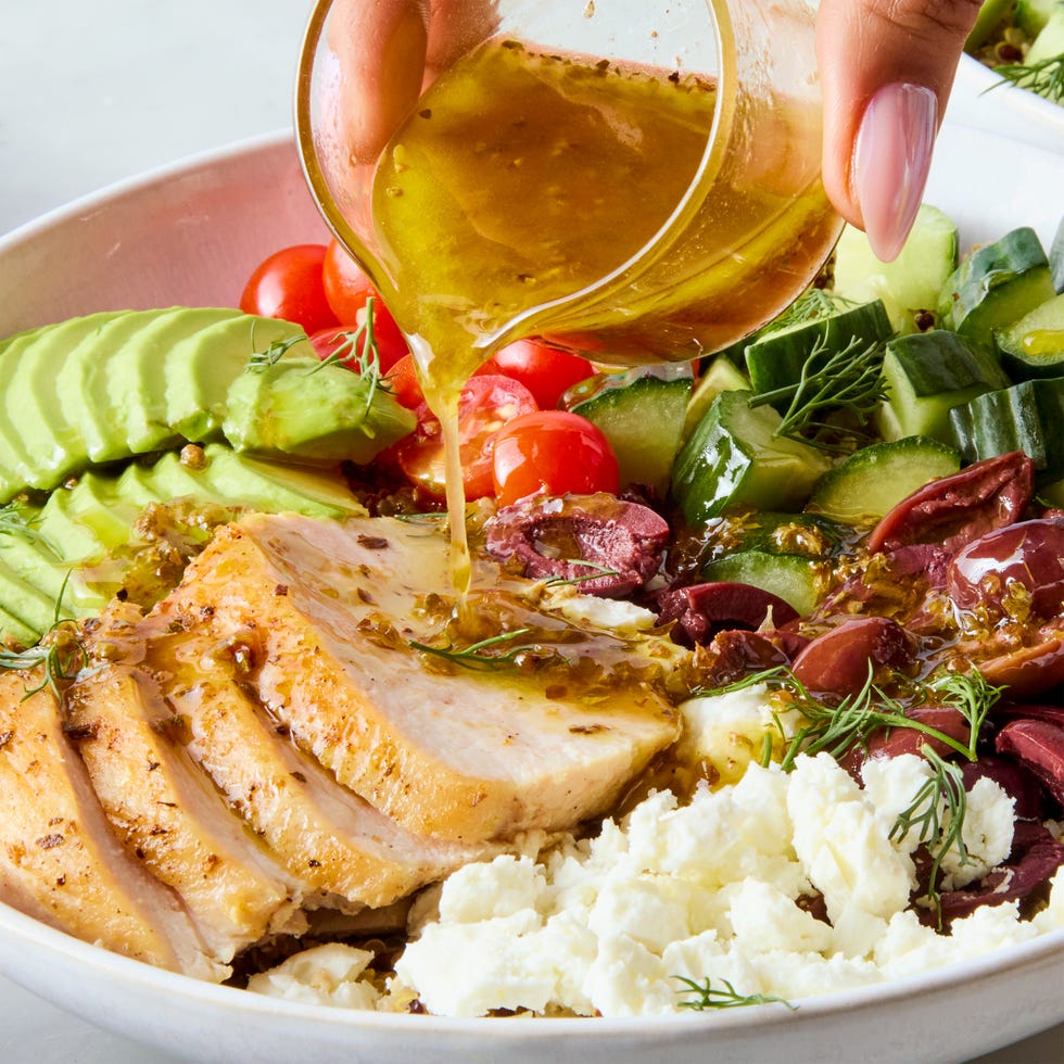 bowls filled with chicken, tomatoes, cucumber, olives, feta, and avocado