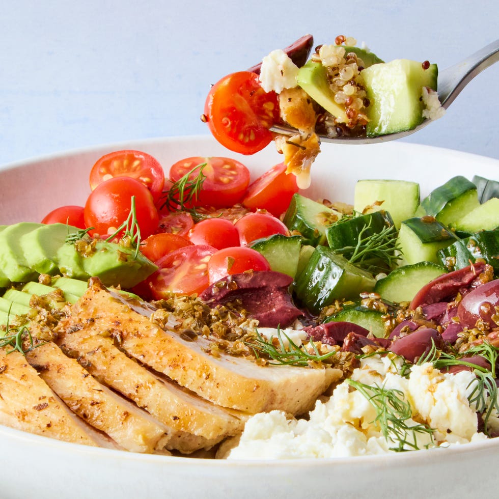 bowls filled with chicken, tomatoes, cucumber, olives, feta, and avocado