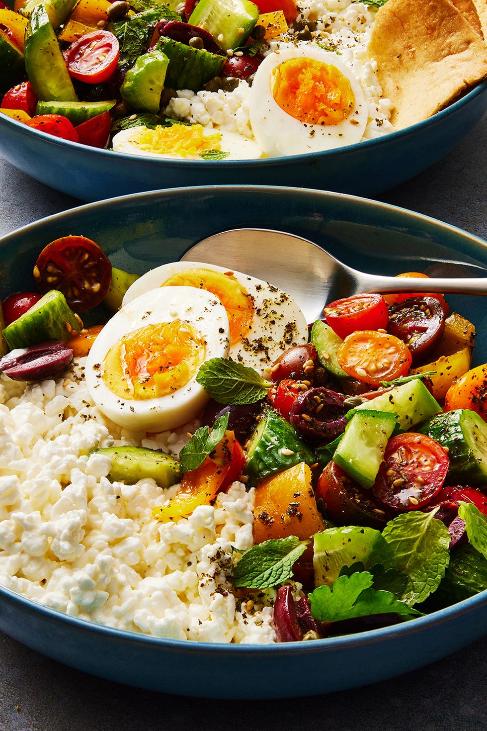 Greek Salad Cottage Cheese Bowl cottage cheese, soft boiled eggs, and a cucumber tomato salad topped with pita chips