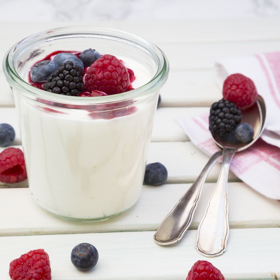 a glass of milk with fruit and a spoon