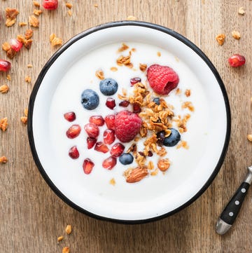 Greek yogurt with granola and berries on wooden table Greek yogurt with granola and berries on wooden table