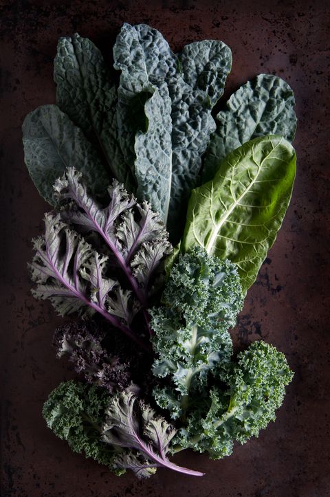 Green and purple kale leaves on rustic background