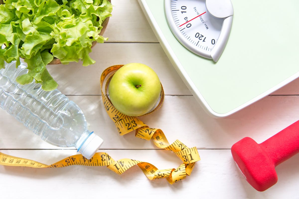 Green apple and Weight scale,measure tap with fresh vegetable, clean water and sport equipment for women diet slimming. Diet and Healthy Concept