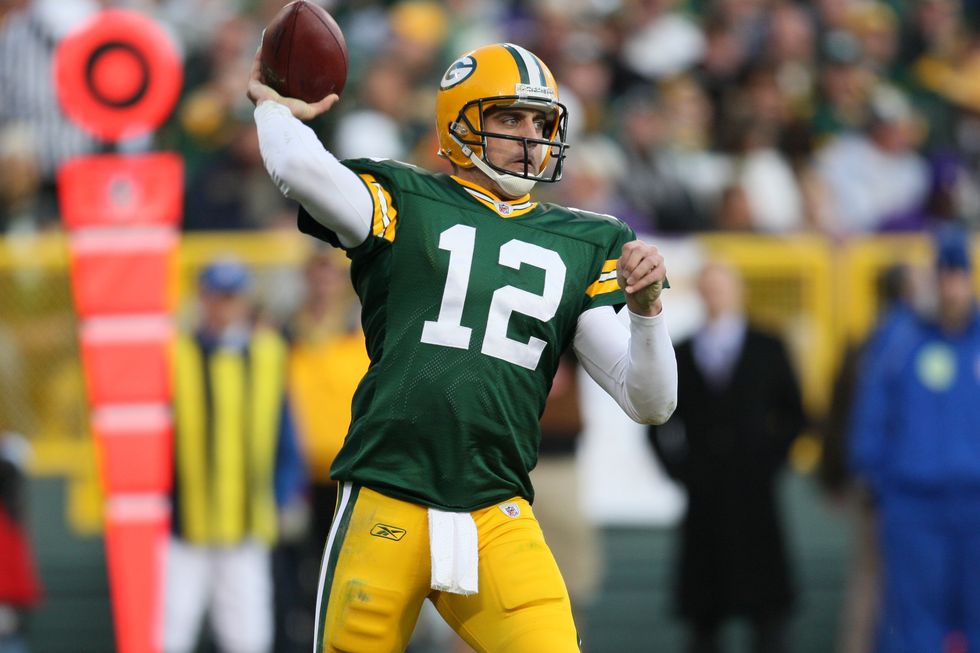 aaron rodgers throwing football in green bay packers uniform