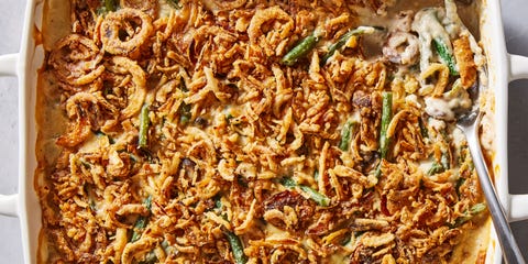 green bean casserole in a white baking dish with crunchy onions on top