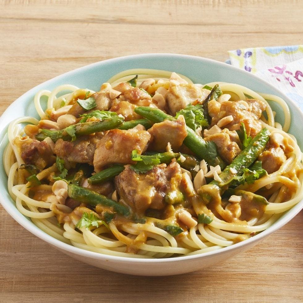 peanut chicken with green beans over noodles in bowl