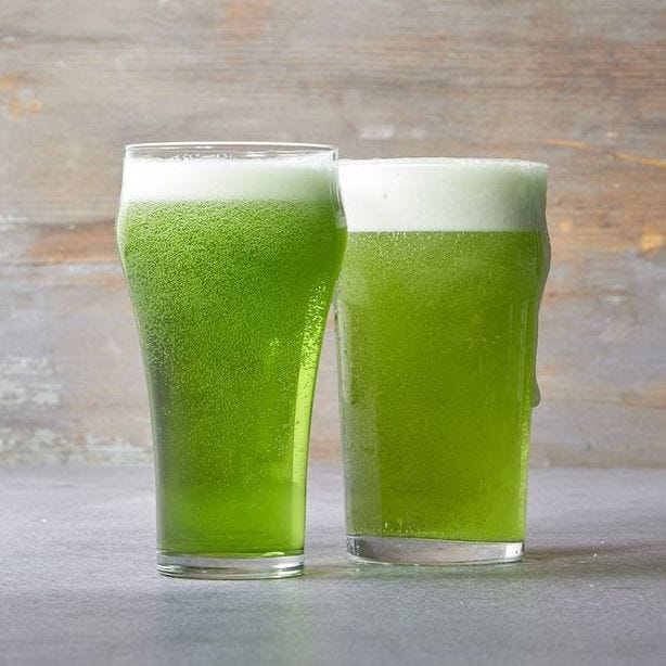 two tall glasses of green beer