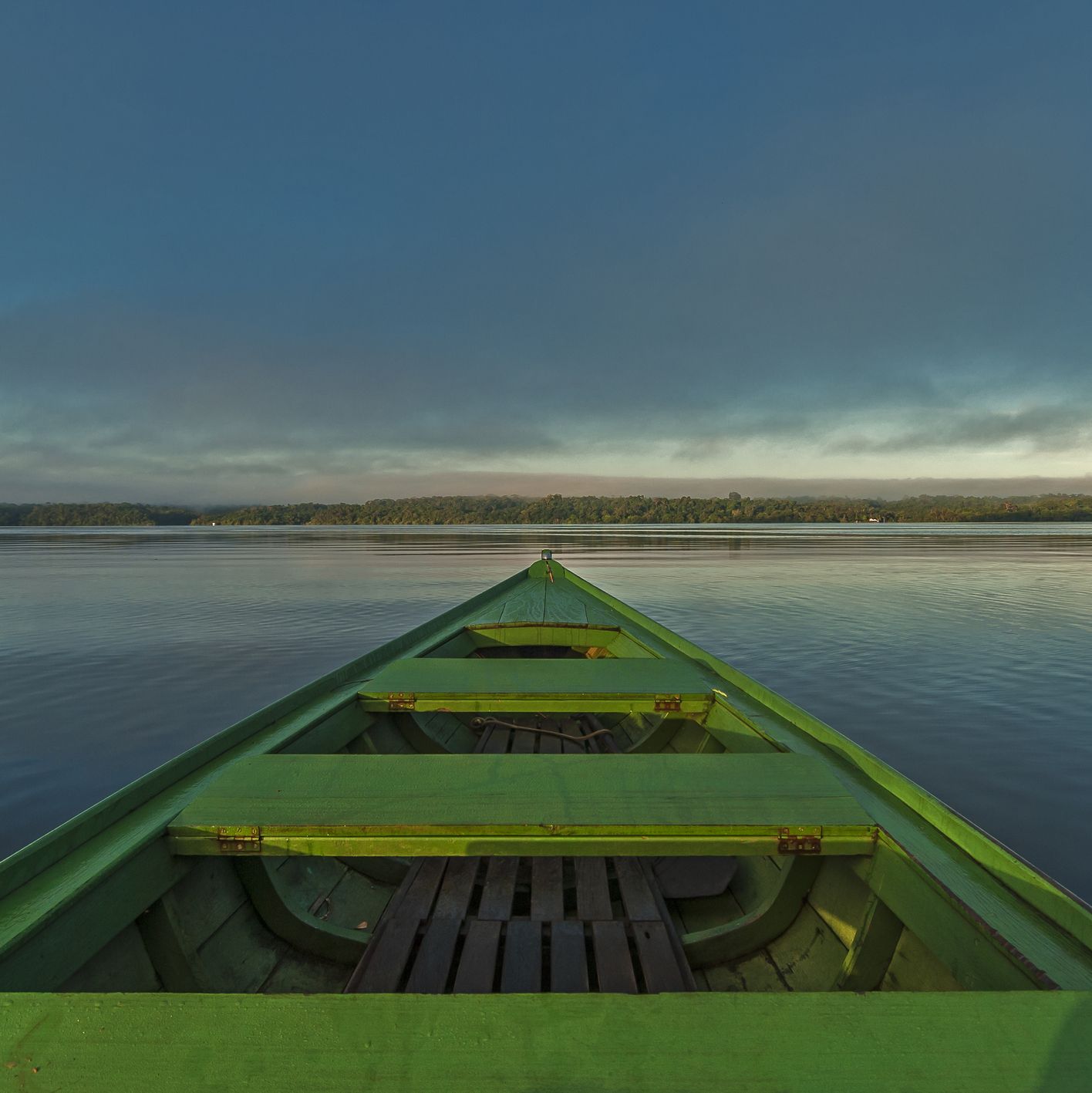 Green boat crossing the Rio Negro river at sunrise in the Amazon region, Anavilhanas Natural Reserve, Amazonas, Brazil