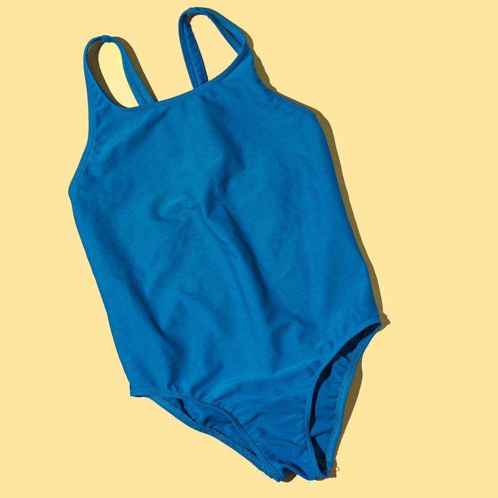 green female swimsuit with hard shadow on yellow background concept of heat, summer, beach, pool, swimming, swimming and sunlight