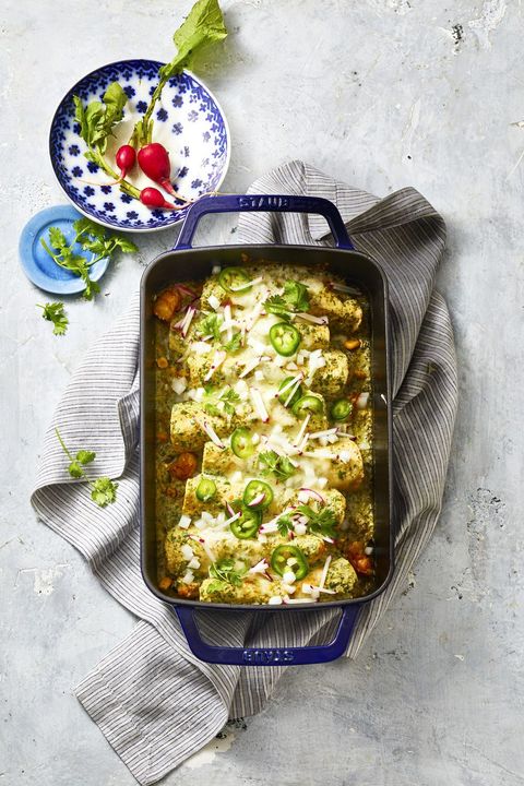 shrimp enchiladas with zucchini and corn in a blue baking dish