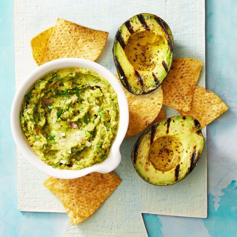 smoky guacamole in a white bowl with chips