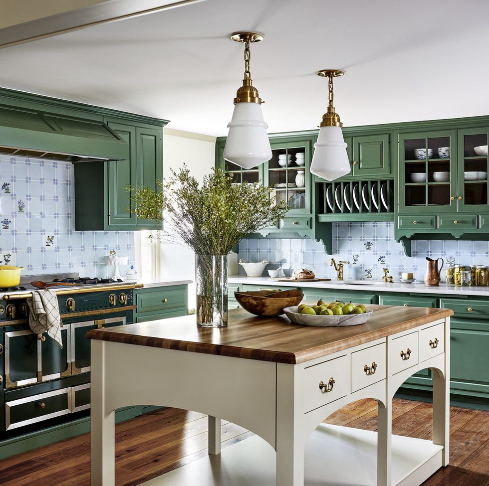 a kitchen with green cabinets and a tan colored island