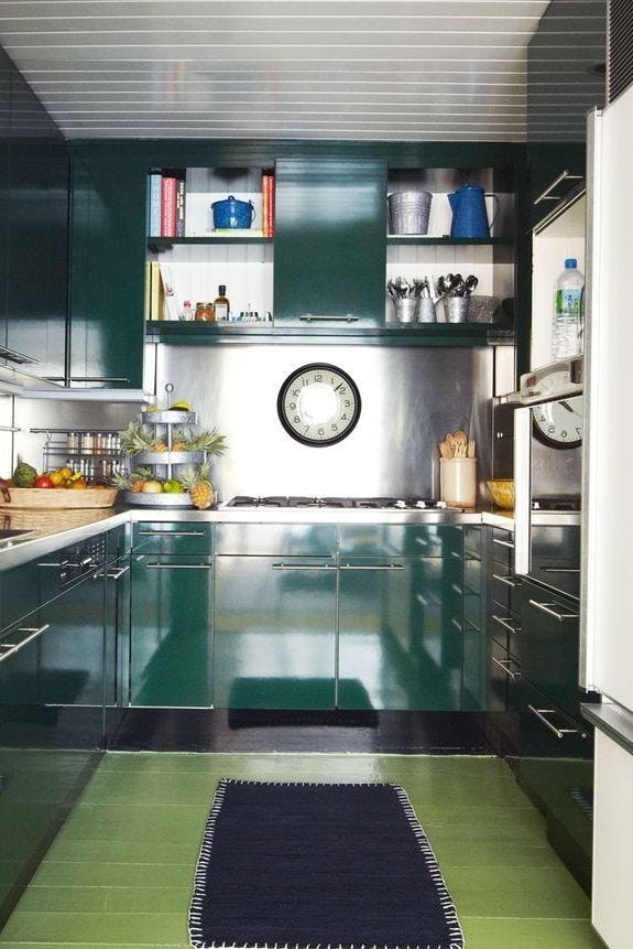 kitchen with green lacquered cabinets a kitchen with green lacquered cabinets, an analog clock, stainless steel appliances, and green floor tiling