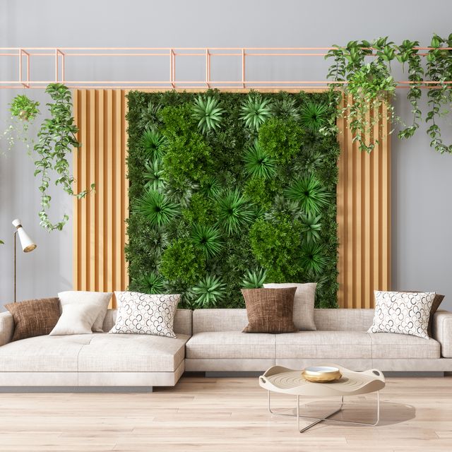 green living room with vertical garden, house plants, beige color sofa and parquet floor