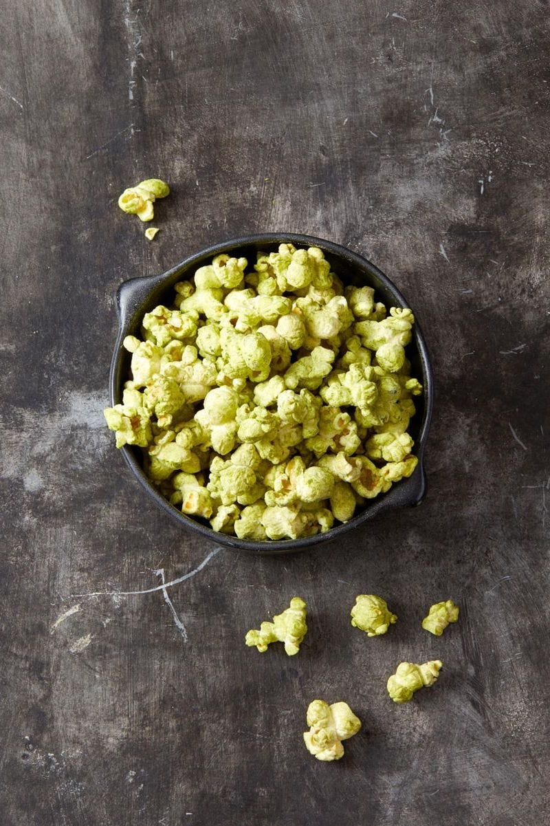 green matcha popcorn in a black bowl