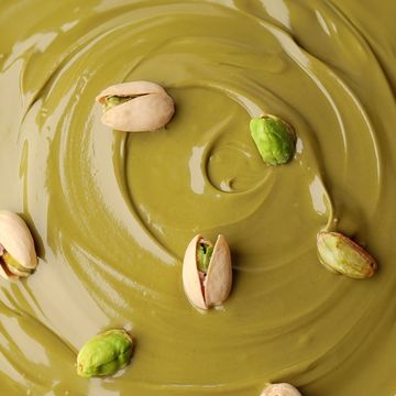 green pistachio paste with pistachio nuts in a shell. pistachio cream