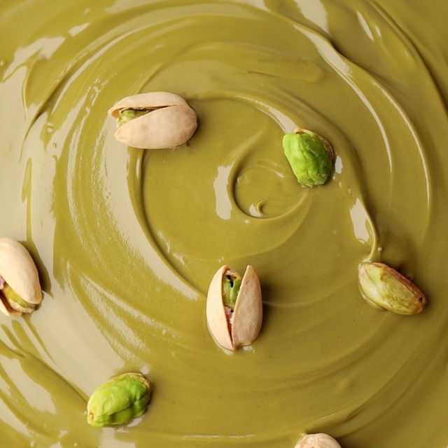 green pistachio paste with pistachio nuts in a shell. pistachio cream