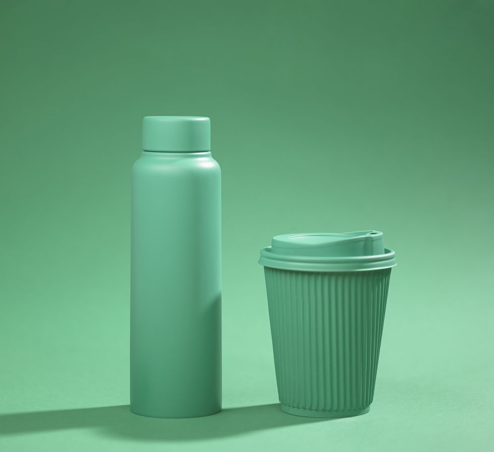 green recyclable cup and reusable bottle on green background