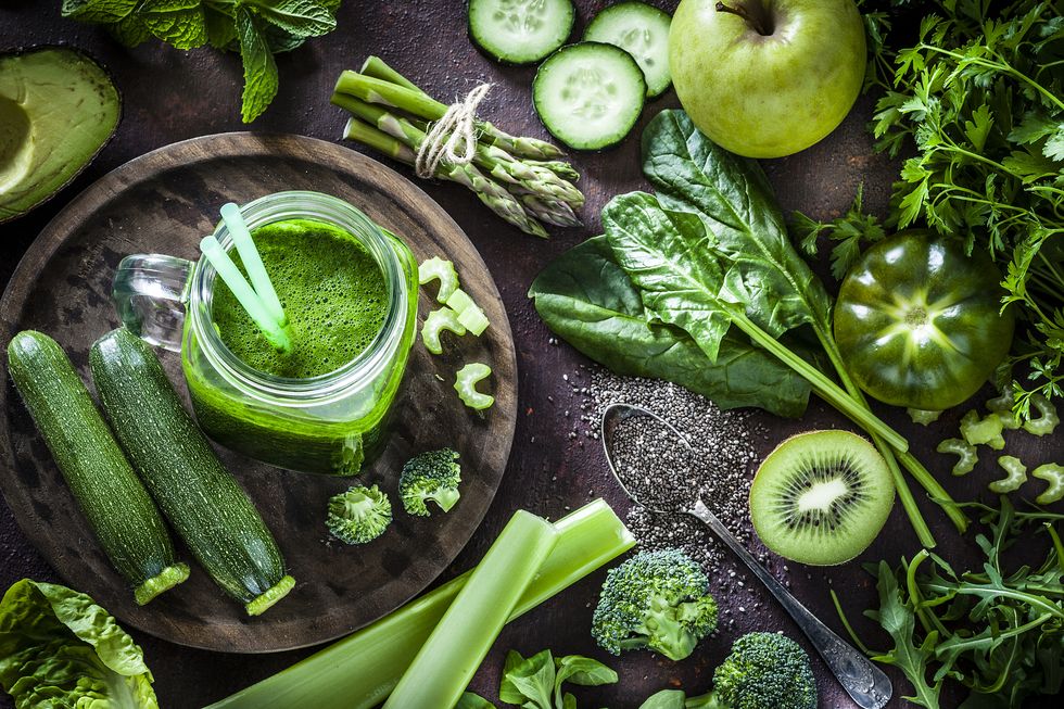 綠色蔬果與綠色蔬果汁擺在木頭桌上