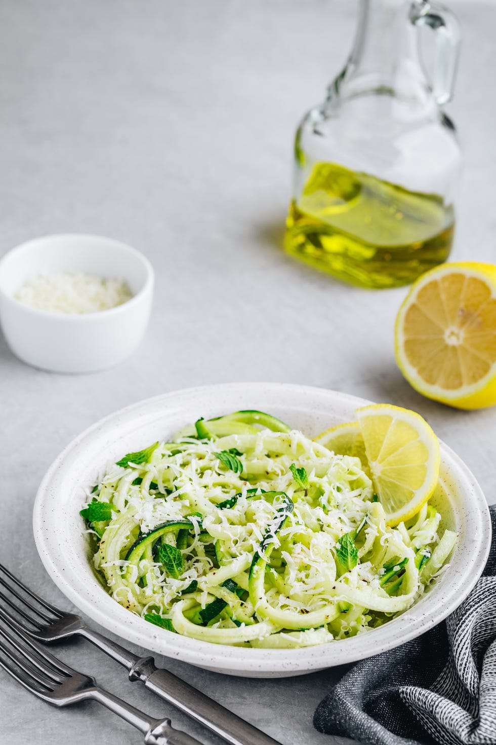 pesto zoodle zucchini pasta with cheese and lemon on top