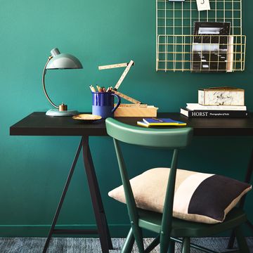 green teal walls behind a desk and a green chair, opulent office, rich teal forms a calming and stylish background to a practical workspace