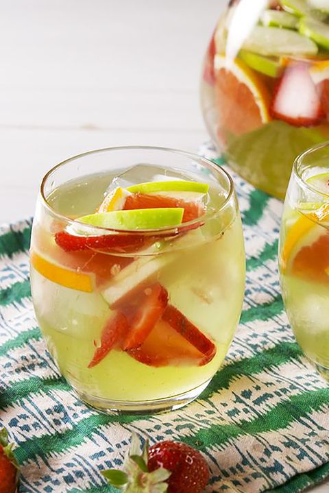glass of green apple moscato sangria with apple slices, oranges, and strawberries floating in it