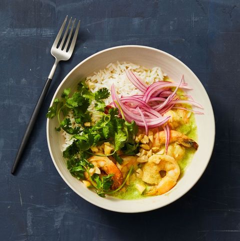 green curry shrimp with white rice and red onions on top