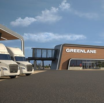 a modern travel plaza with ev charging stalls next to it with parked semi trucks