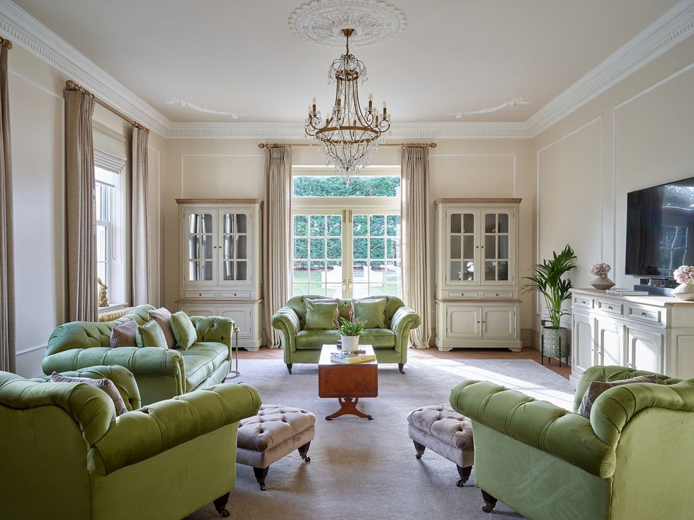 a living room with green couches in the white house in essex