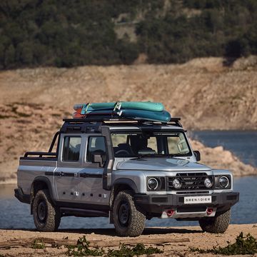 a silver four door truck with two boards on the roof sits in front of a flooded canyon