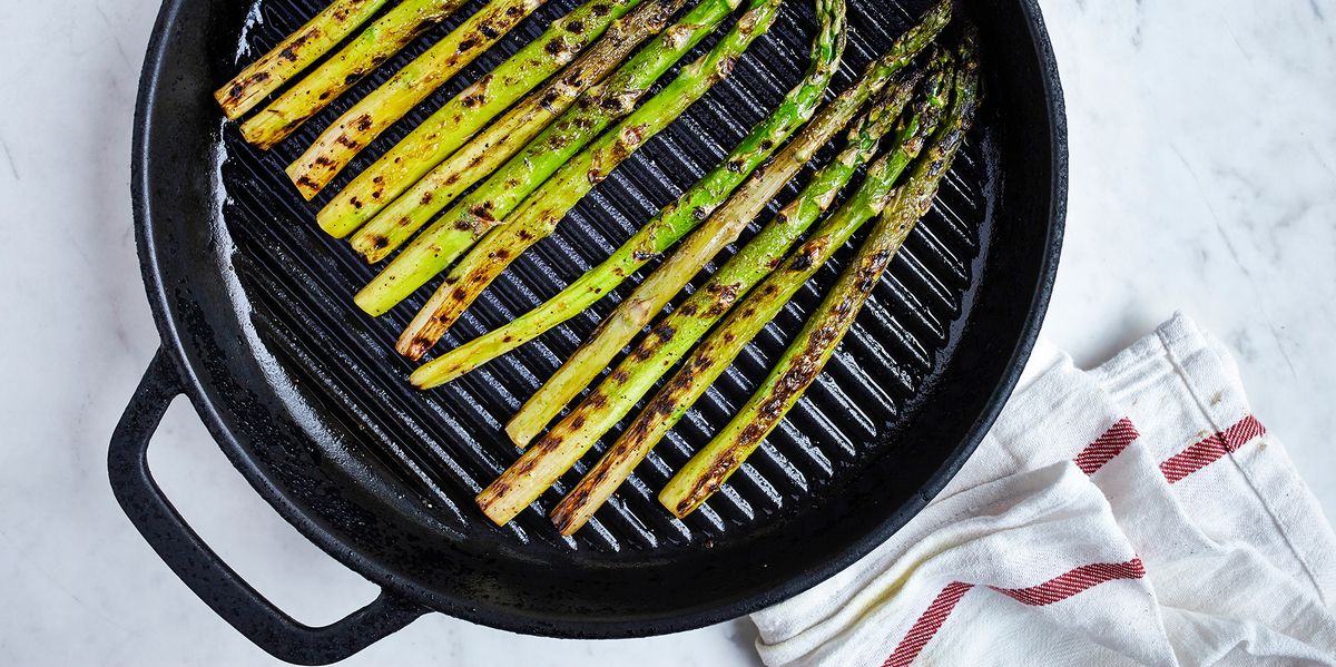 asparagus in grill pan on marble countertop with dish towel