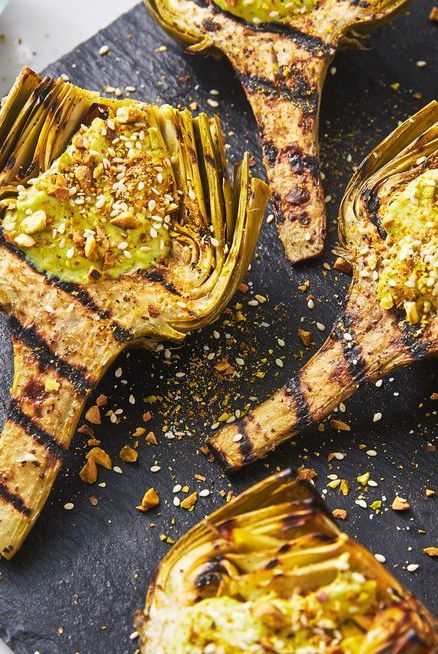 grilled artichokes topped with green yogurt sauce and sesame pistachio crumble