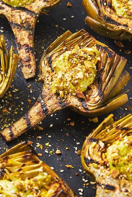 grilled artichokes topped with avocado, pistachos, and sesame seeds
